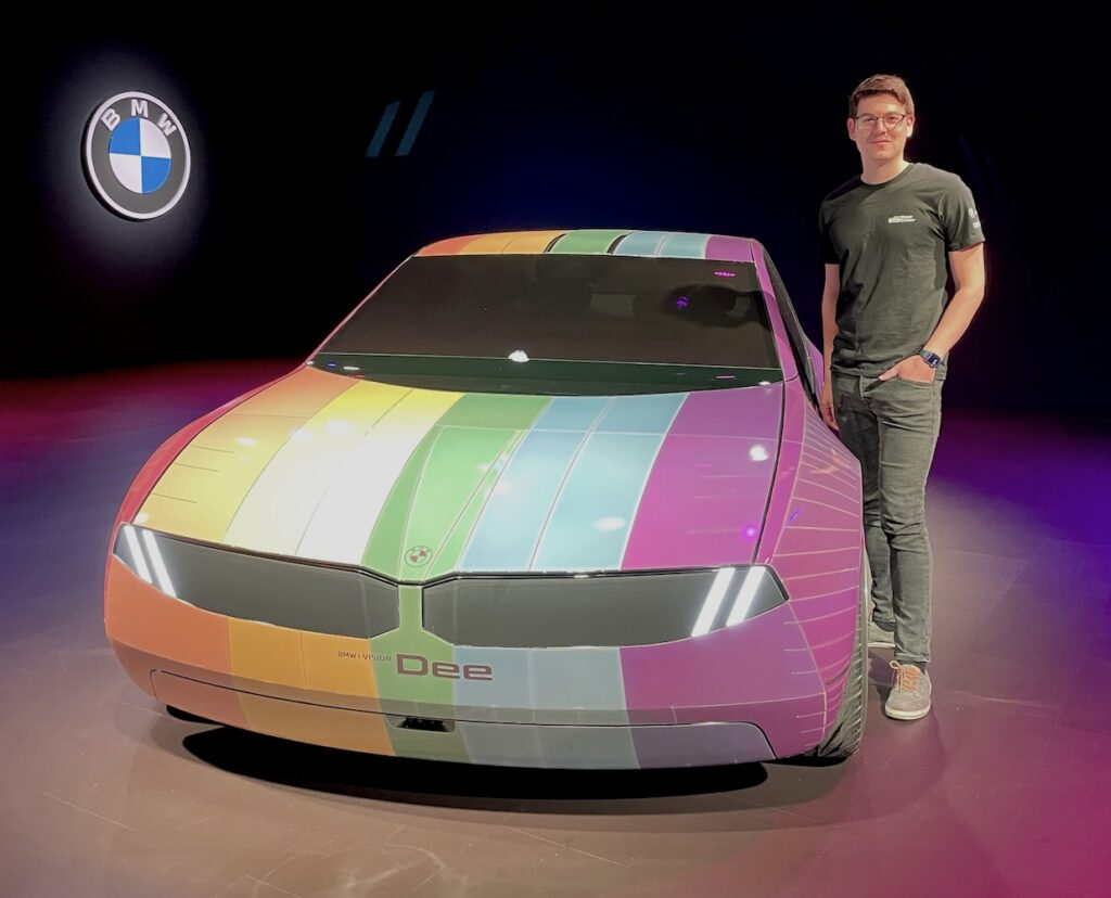 Flo standing next to BMW Dee color E-Ink Car